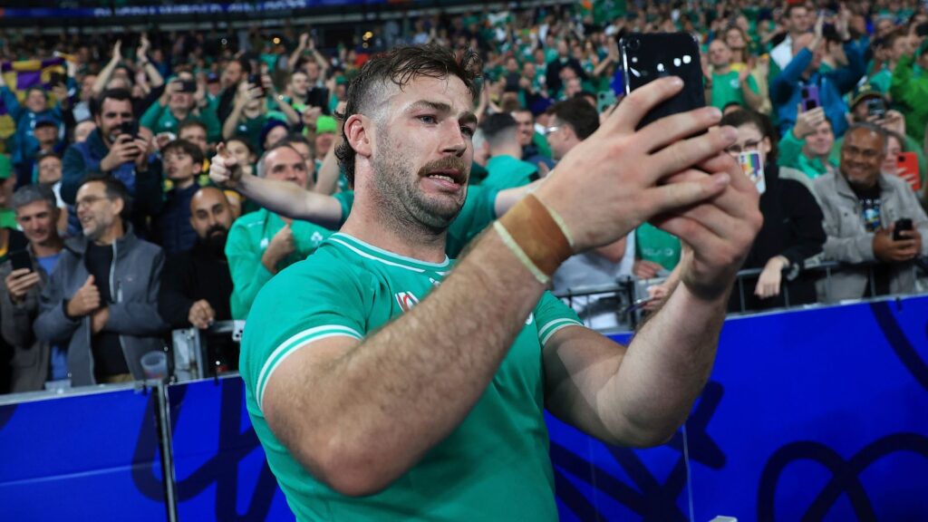 Ireland's Caelan Doris takes a photo on a phone after the end of the Rugby World Cup Pool B match between South Africa and Ireland at the Stade de France in Saint-Denis, outside Paris, Saturday, Sept. 23, 2023. Ireland won the game 13-8. (AP Photo/Aurelien Morissard)