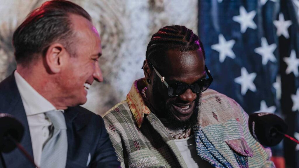 Deontay Wilder laughs with Kalle Sauerland during a press conference ahead of his fight with Derek Chisora
